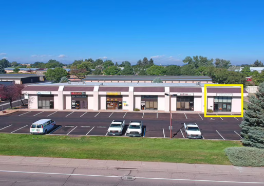 Retail/Office Space For Lease -A retail strip mall with several storefronts and a parking lot in front of the building.