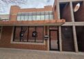 Office For Lease-809 9th St, Unit 2A, Greeley, CO 80631 - A brick building with large windows, a mailbox labeled "mail drop," and a glass door. The building features tan trim and a covered walkway with a brick-paved sidewalk in front.