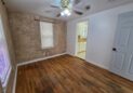 For Sale or Lease-222 Oak Ave, Eaton, CO 80615. An office with hardwood floors, two windows with white blinds, beige textured walls, and a ceiling fan with lights is shown.