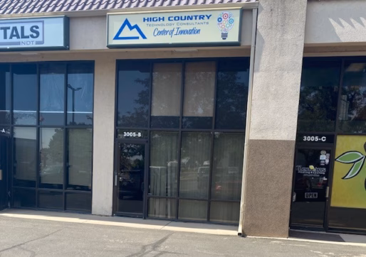 Office/Warehouse For Lease-A storefront with a sign reading "High Country Technology Consultants Center of Innovation" above tinted glass doors and windows, located between two other businesses in a small commercial plaza.